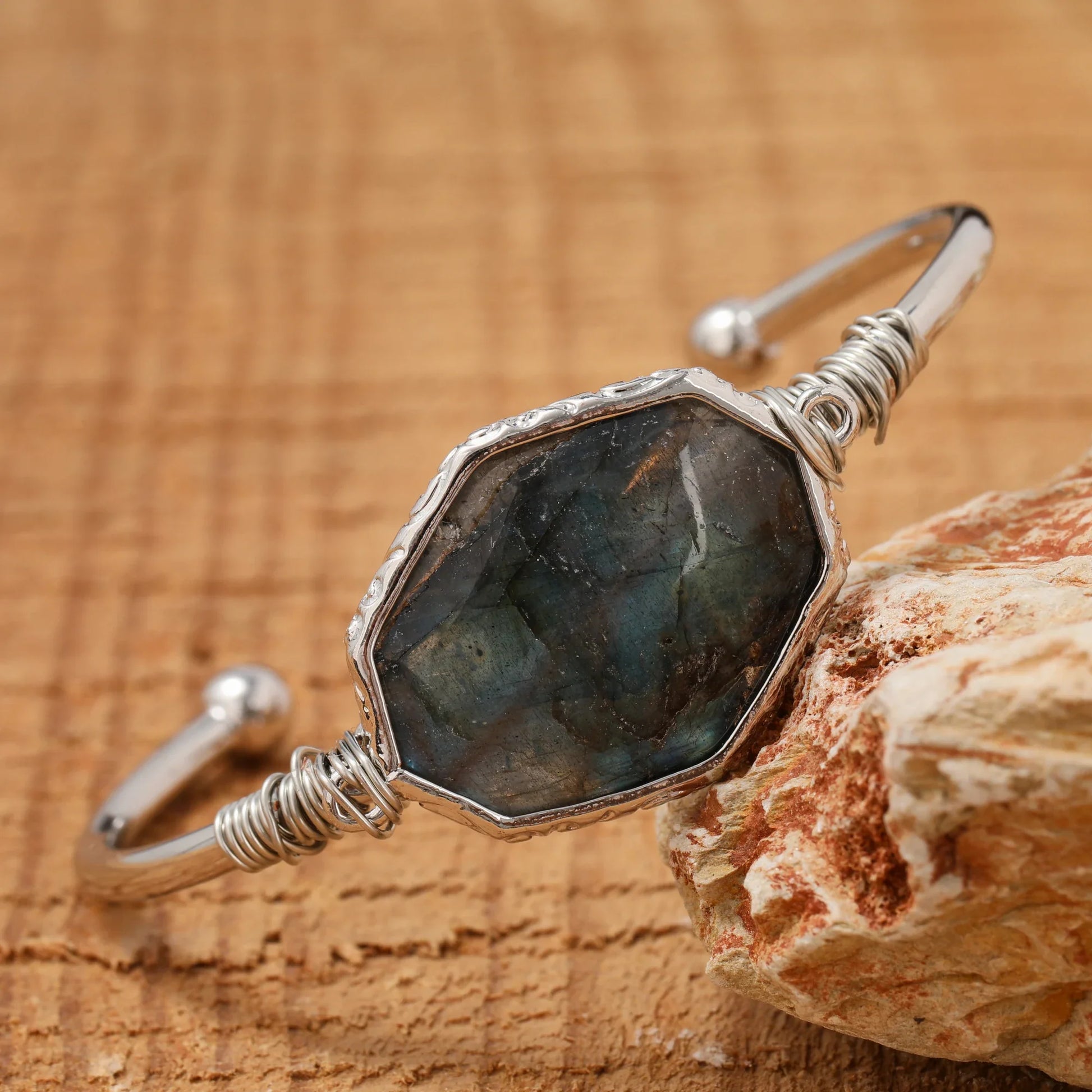 Silver bracelet with a large stone on a wooden surface