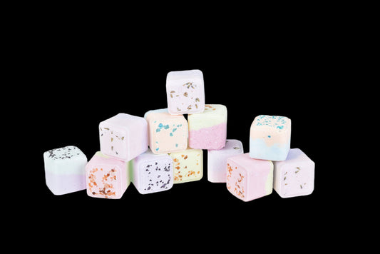 Pastel-colored marshmallows stacked on a white background