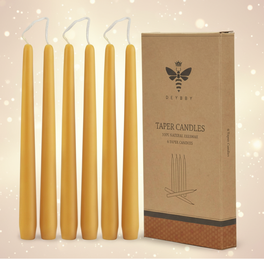 Set of six yellow taper candles with a cardboard box labeled 'DEBBY' on a white background.