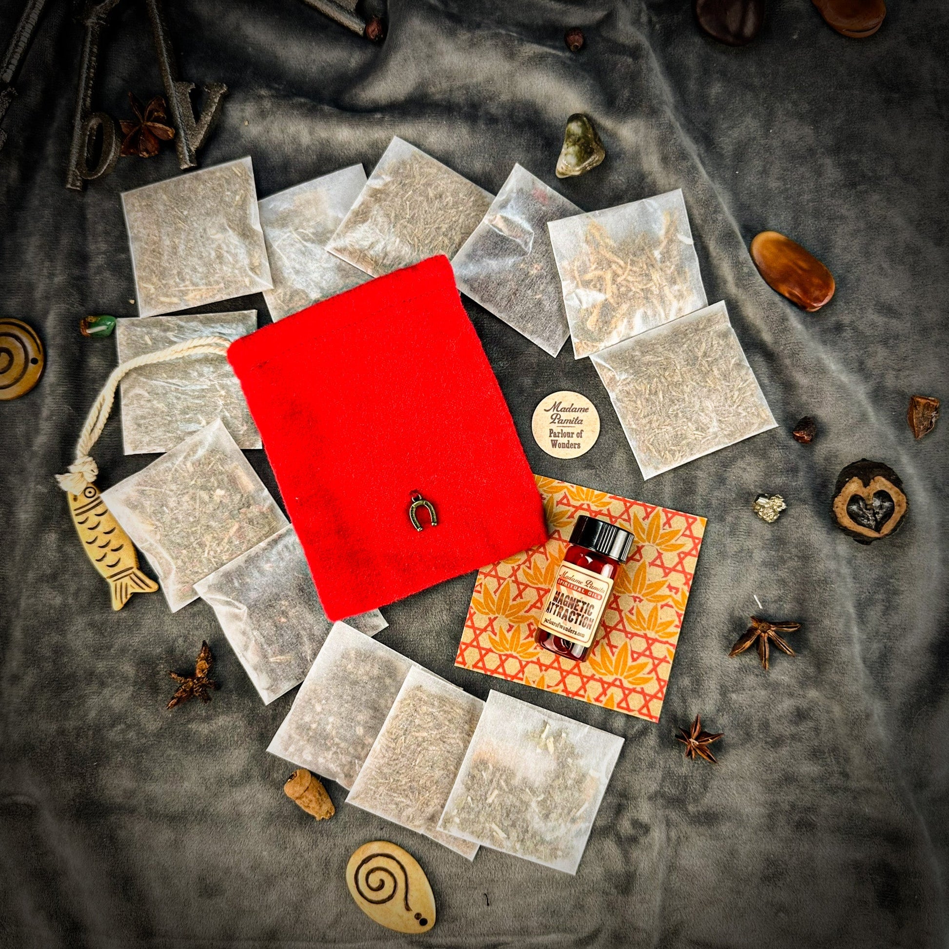 Red pouch, tea bags, and a bottle on a textured surface with decorative elements.