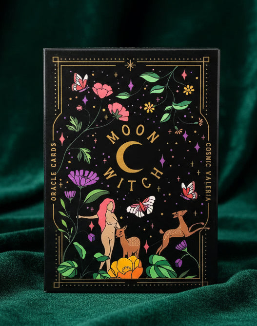 Ornate packaging for 'Moon Witch' Oracle Cards with illustrations of a woman, deer, and flowers on a black background.
