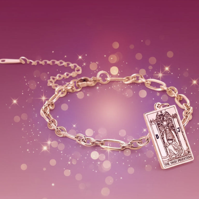 Gold bracelet with tarot card charm on a white background