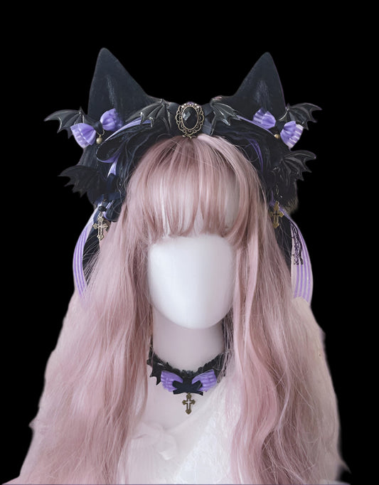 Black cat ears headband with purple accents on a mannequin head with pink hair against a floral background.