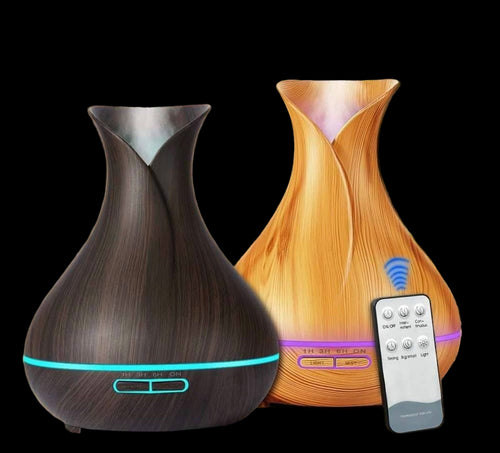 Two wooden diffusers with a remote control on a wooden surface.
