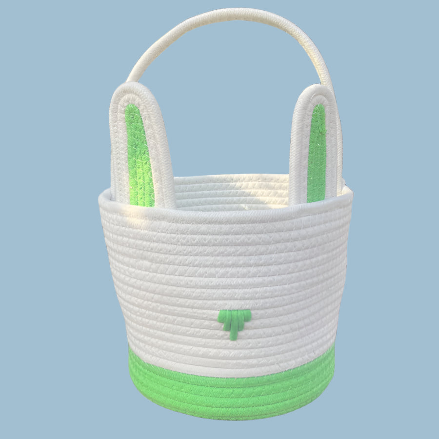 White woven basket with green base and handle on a white background