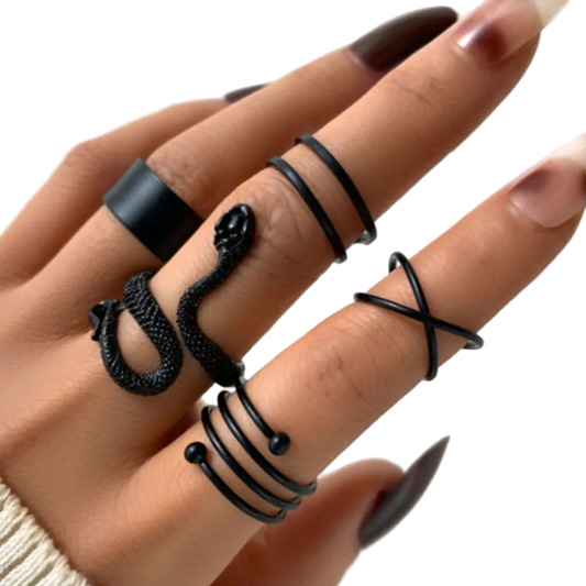 Close-up of a hand wearing multiple black rings on a light background