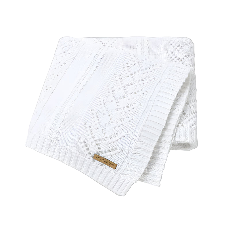 White knitted blanket with a brand label on a white background