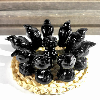 Black ceramic birds arranged in a circular pattern on a woven mat with a wooden background.