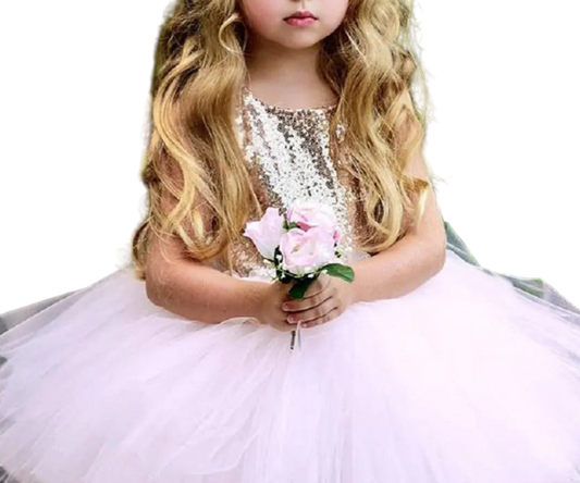 Young girl in a sparkly dress holding flowers with a green leafy background
