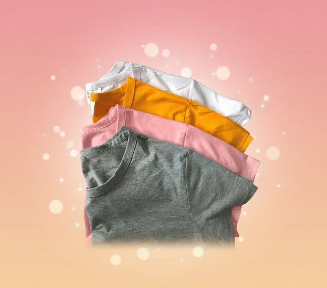 Stack of folded shirts in various colors on a cardboard surface