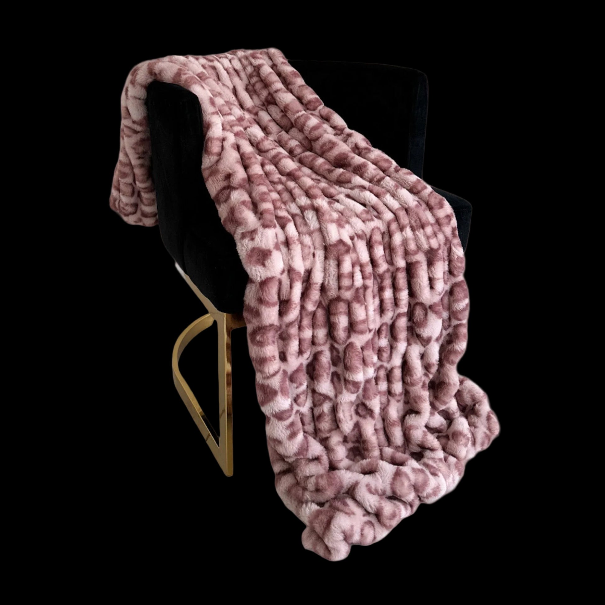 Pink textured blanket draped over a black chair on a white background