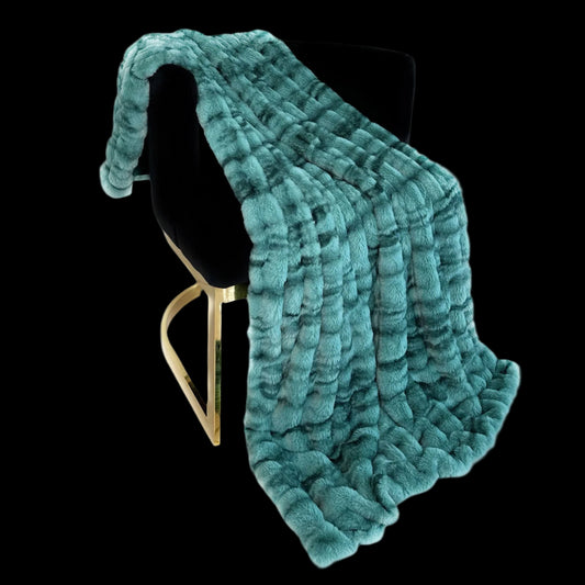 Teal textured blanket draped over a black chair on a white background
