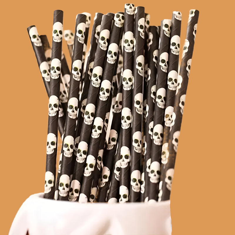 Black paper straws with skull patterns in a holder against a blurred background