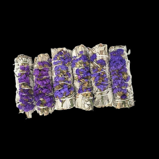 Five bundles of smudge sticks with purple flowers on a white background