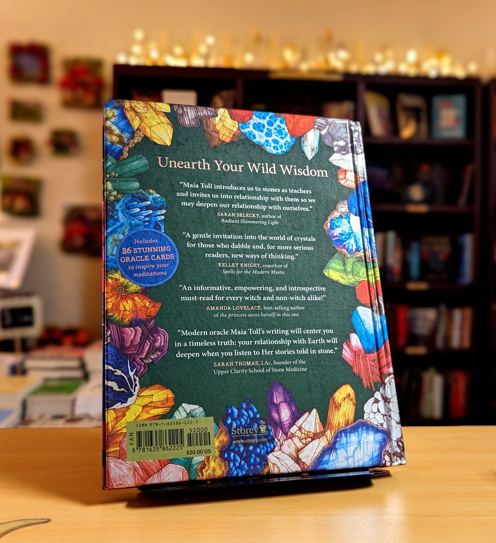 Colorful book cover with text and crystal graphics on a wooden surface.