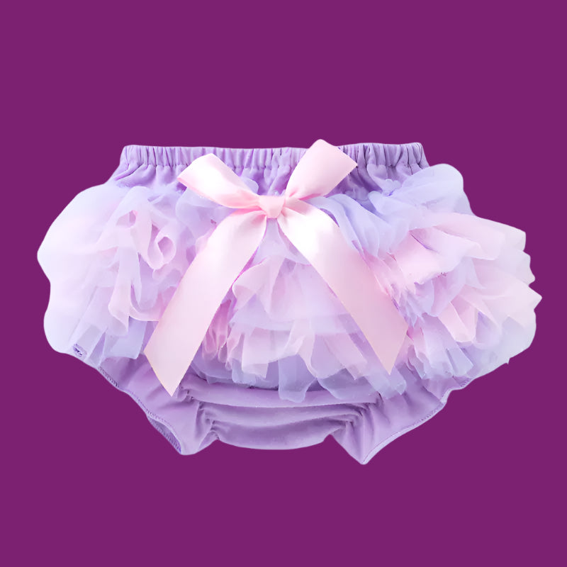 Purple baby bloomers with a pink bow on a light purple background