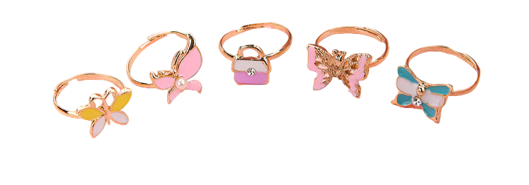 Set of butterfly-themed rings on a pink surface with flowers in the background