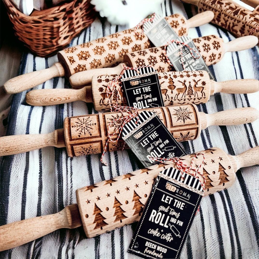 Set of wooden embossed rolling pins with engraved patterns on a striped fabric background
