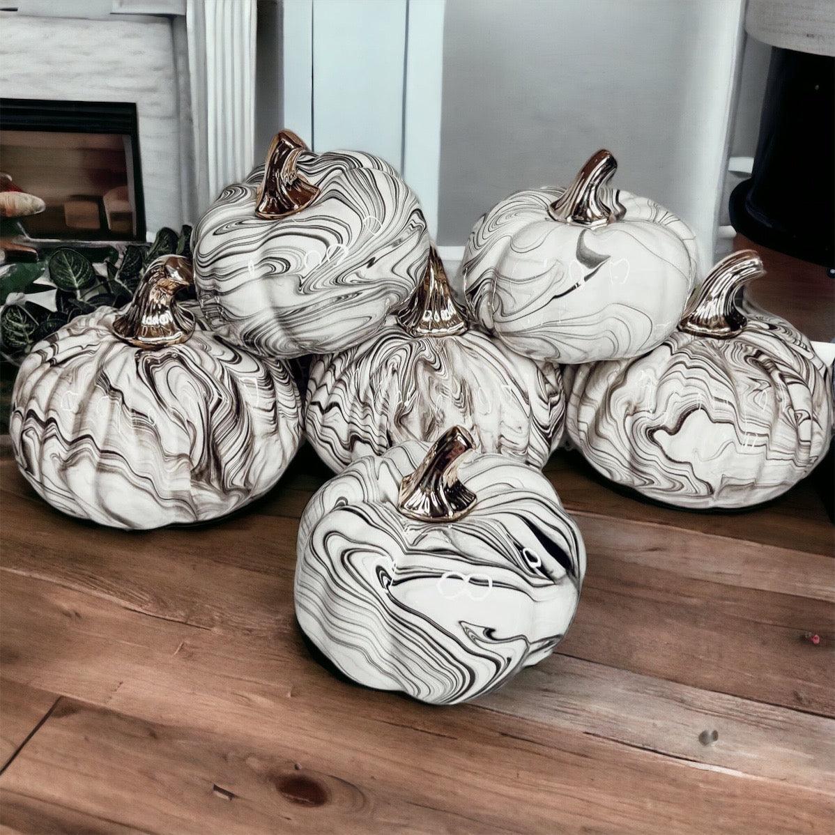 Decorative pumpkins with marble pattern on a wooden surface