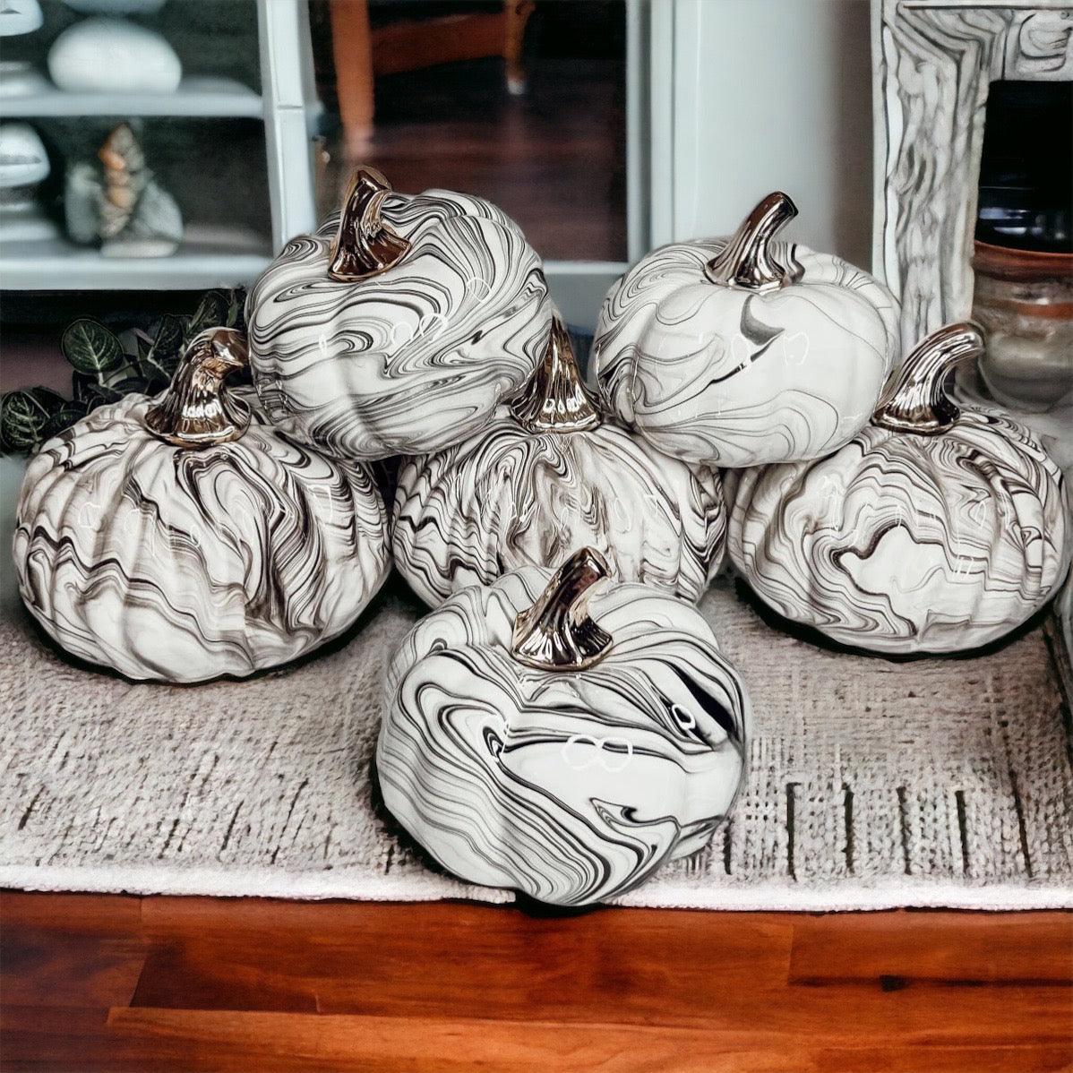 Decorative pumpkins with marble pattern on a textured surface