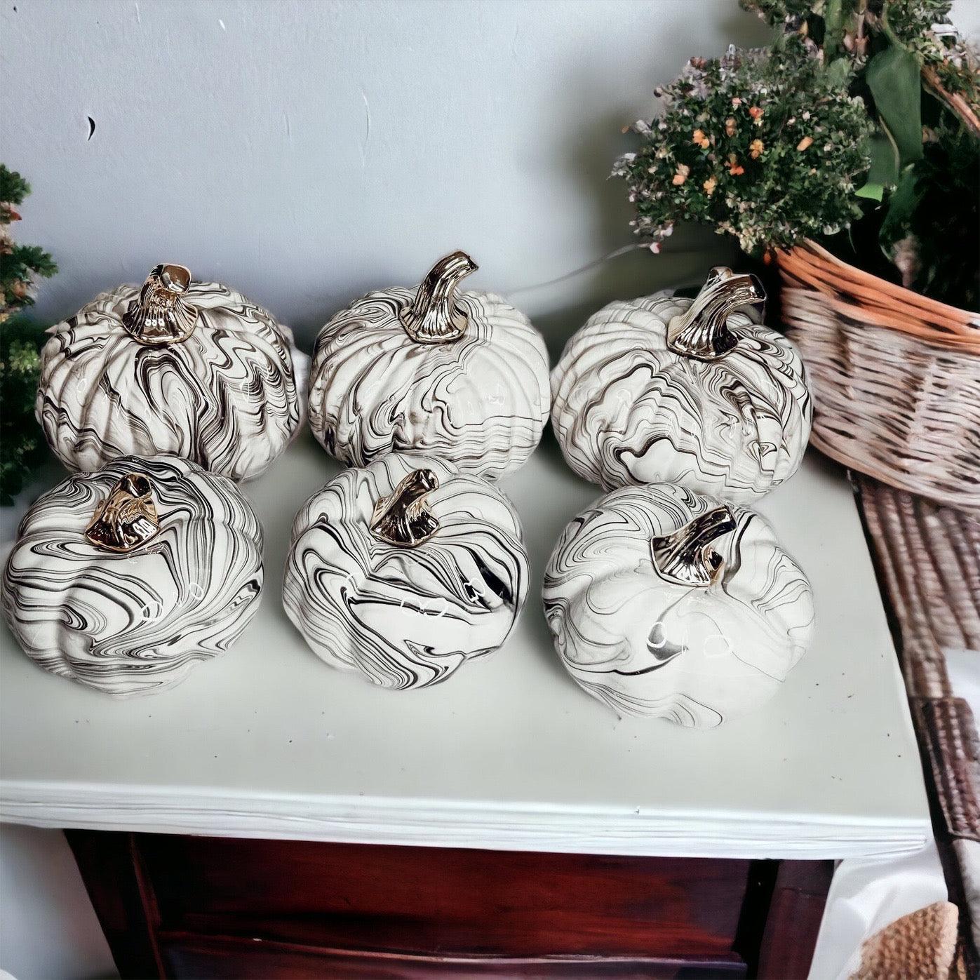 Decorative white pumpkins with black patterns on a table