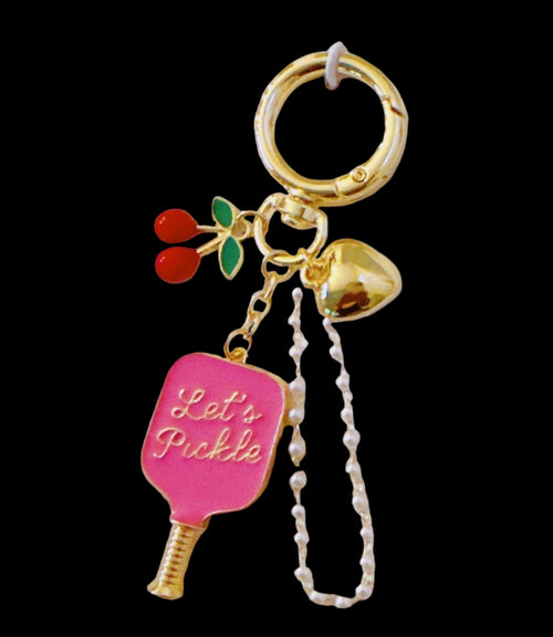 Two bag charms on their packaging with 'Let's Pickle' text on a beige background