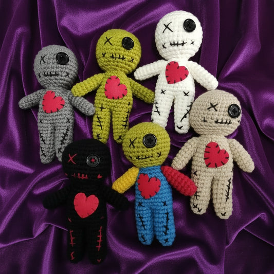 Set of colorful crochet dolls with heart designs on a gray background