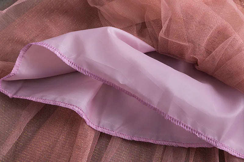 Close-up of pink fabric with brown tulle, possibly a skirt or dress detail.
