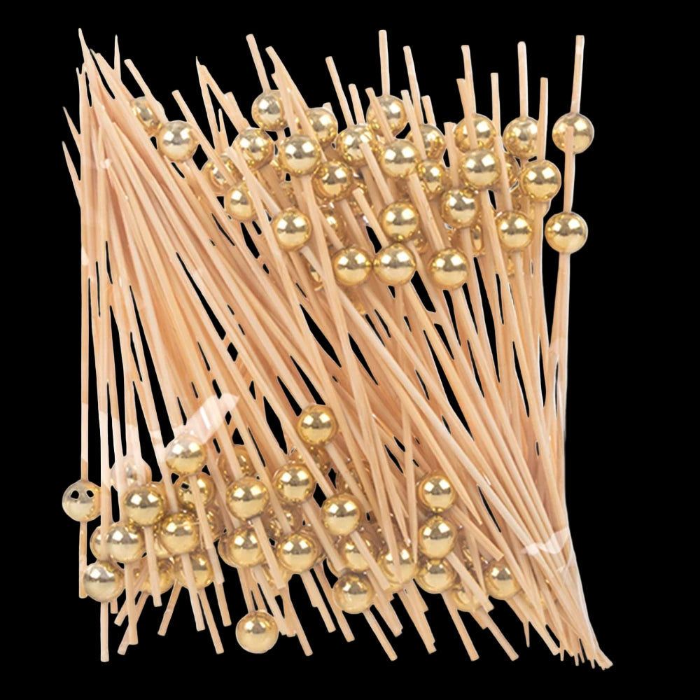 Packaged toothpicks with gold ball ends on a white background