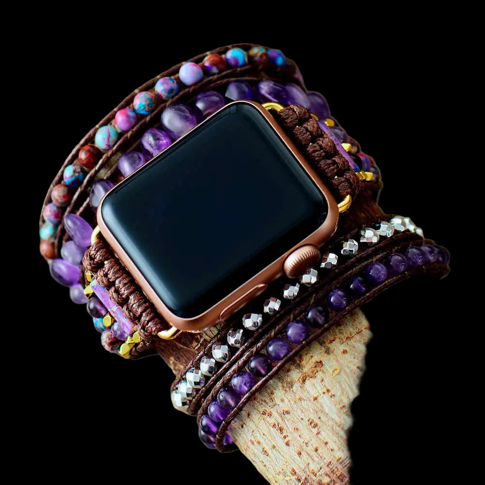 Smartwatch with a decorative leather strap featuring beads on a wooden surface