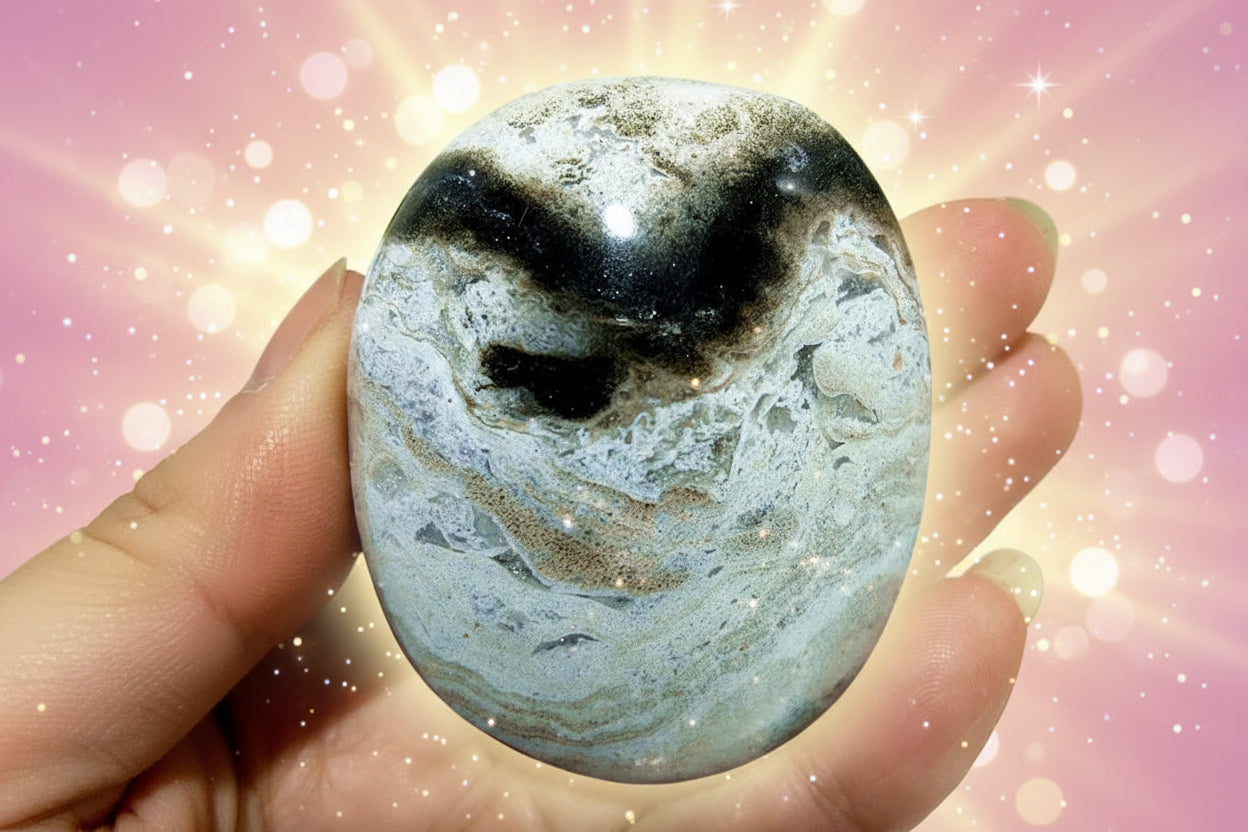 Marbled stone held in a hand with a blurred green background