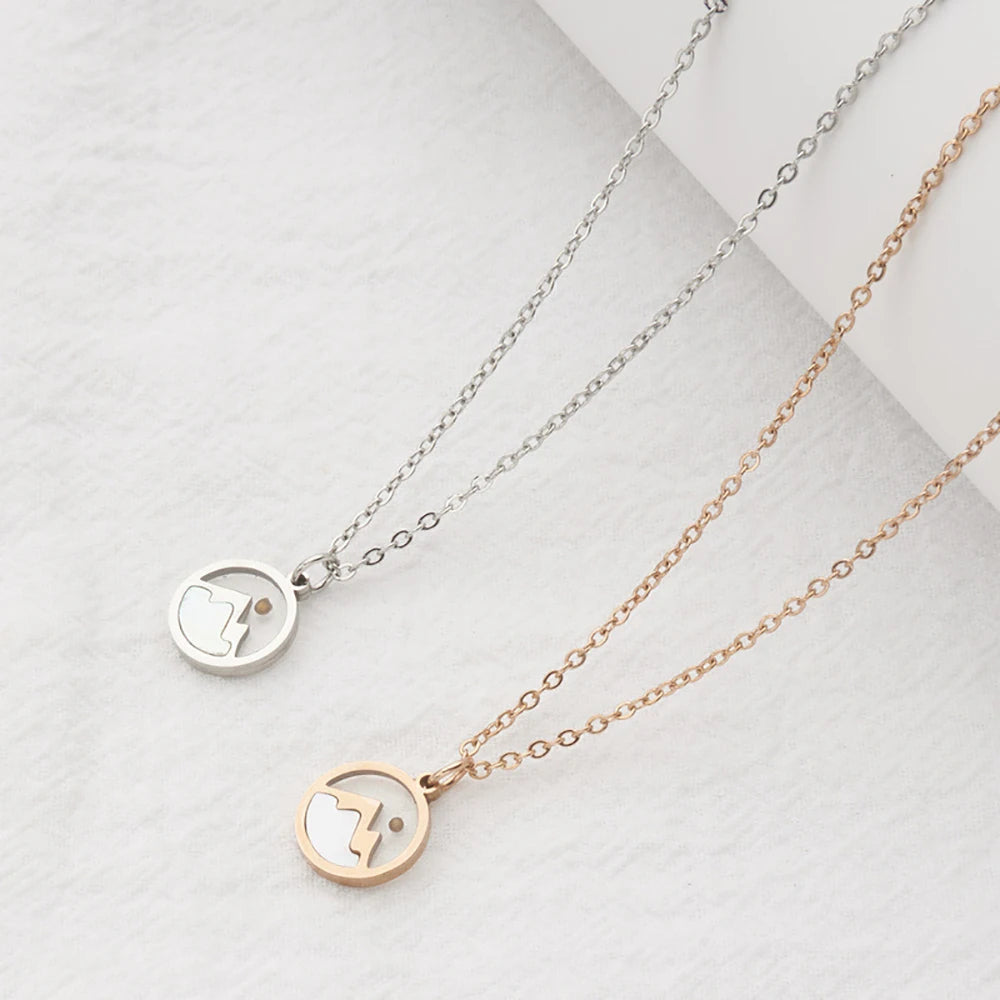 Two necklaces with circular pendants on a light gray background