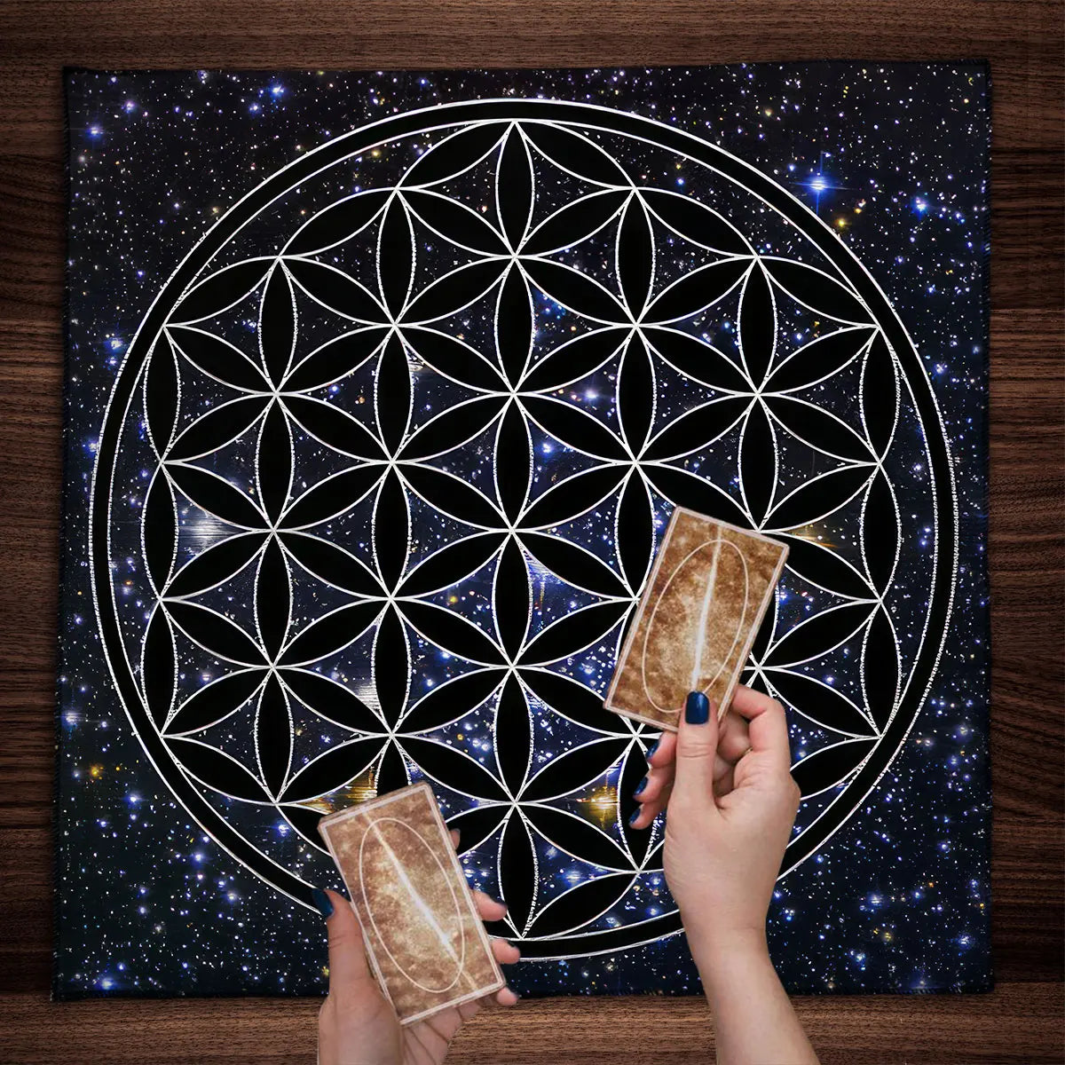 Two tarot cards held by hands in front of a cosmic design with a starry night sky.