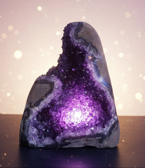 Amethyst geode on a reflective surface with a neutral background