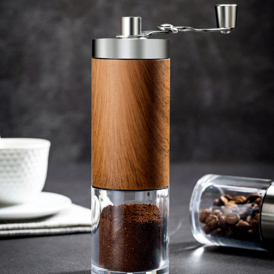 Wooden coffee grinder with coffee beans and a cup on a dark background