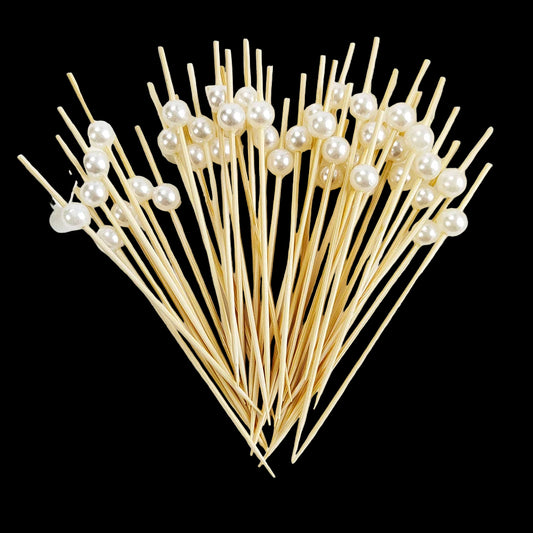 Wooden skewers with pearl beads on a white plate
