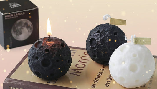 Moon-themed candles on a book with a box labeled 'Moon Candle' in the background.