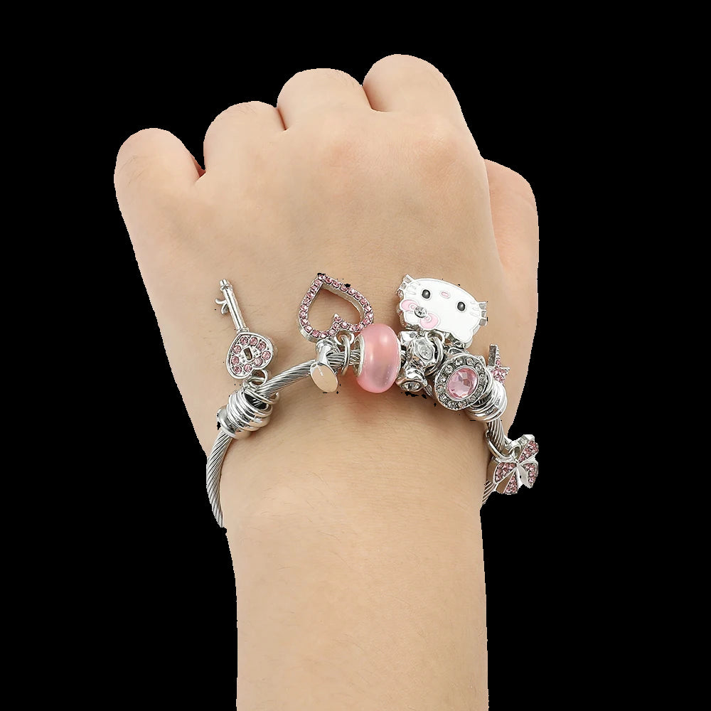 Hand wearing a bracelet with various charms on a white background