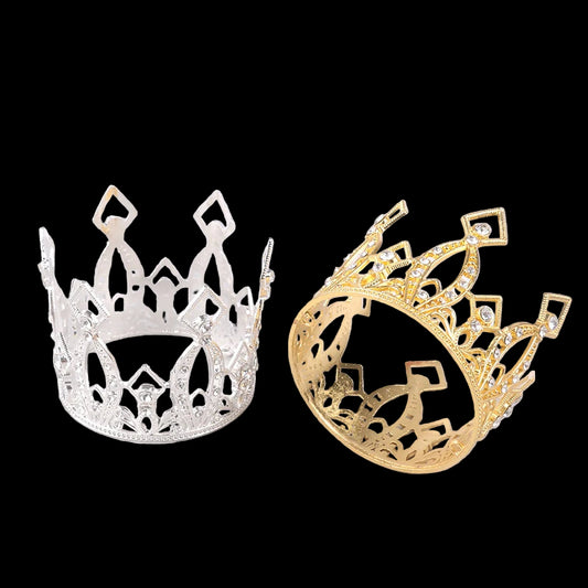 Gold and silver tiaras on a light gray surface with a white background