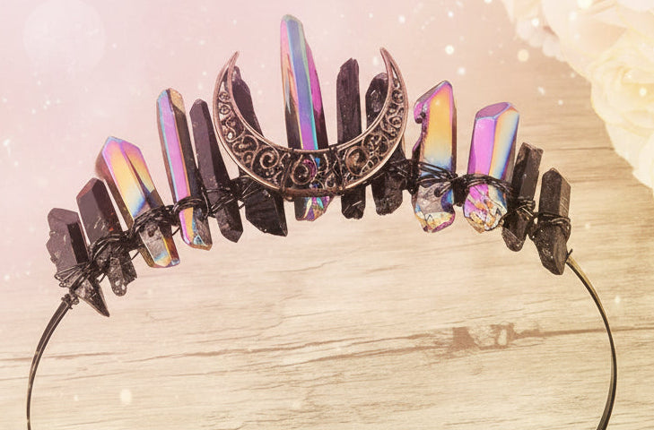 Decorative headband with rainbow and black stones on a wooden surface