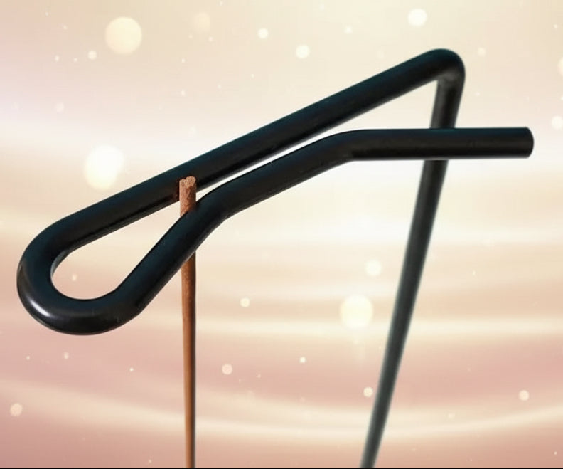 Black metal U-shaped tool on a white surface with a blue background