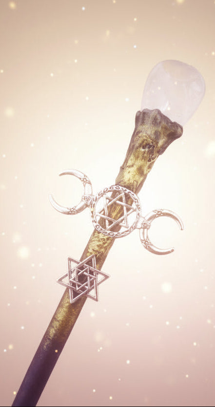 Decorative staff with crystal and metallic symbols on a dark background