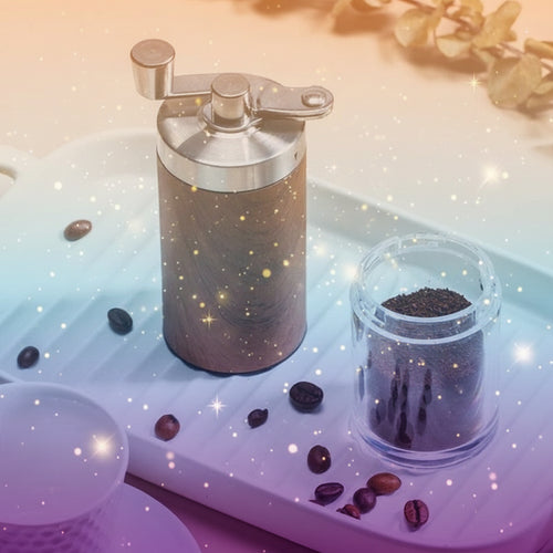 Wooden coffee grinder with ground coffee on a white tray