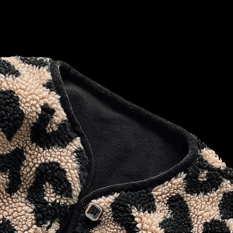 Close-up of a black and beige leopard print fabric with a button on a light gray background
