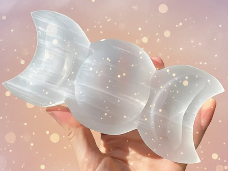 Hand holding a white stone sculpture with a natural outdoor background