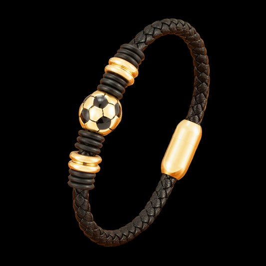 Black braided bracelet with gold accents and a soccer ball charm on a wooden surface