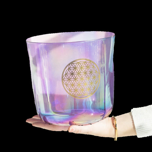Iridescent glass container with gold geometric design held by a hand