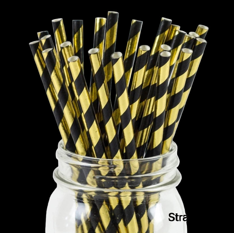 Black and gold striped straws in a glass jar on a white background