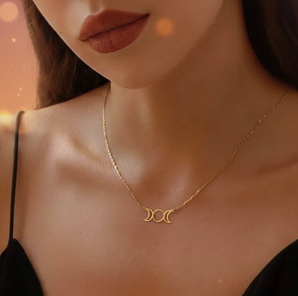 Woman wearing a gold necklace with a green blurred background