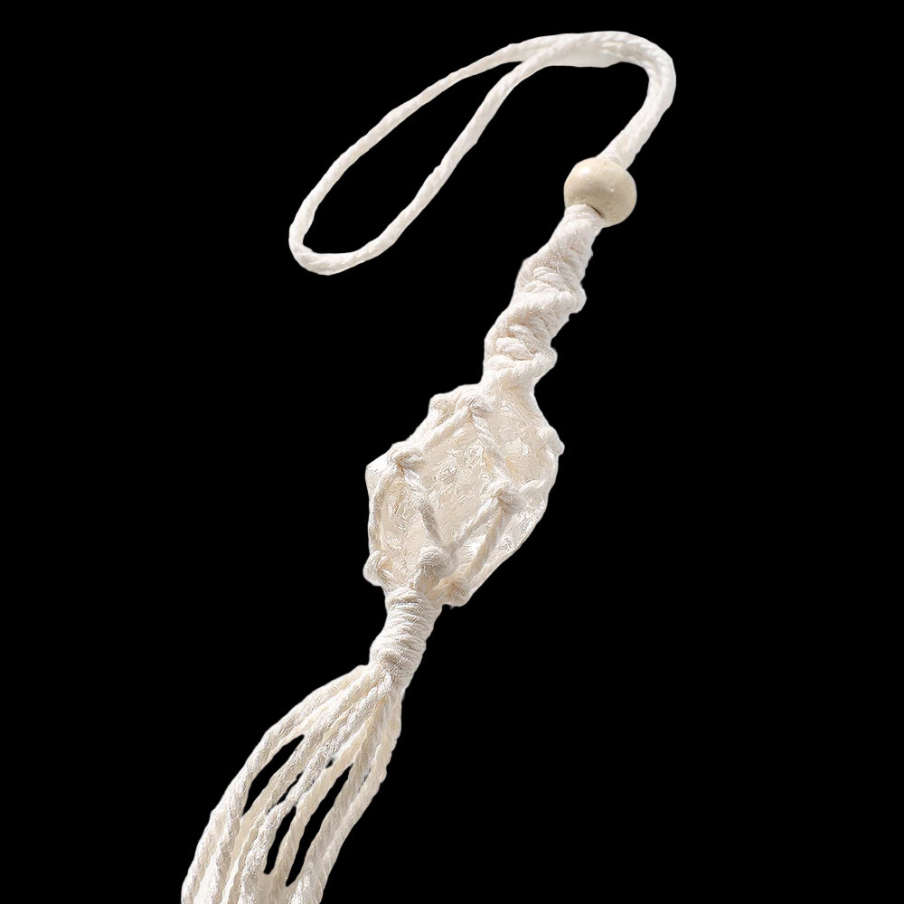 Macrame wall hanging with a tassel on a light background